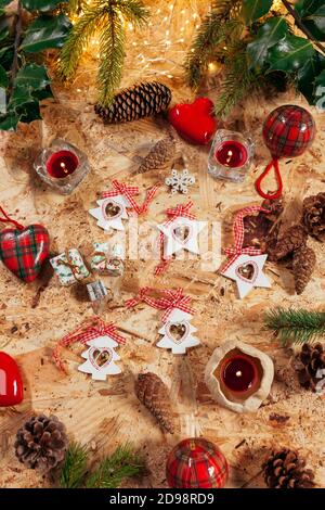 Weihnachtsdekoration Stillleben mit Kiefernzapfel, rote Kerzen, weihnachtssterne, leds Leuchten und Baumschmuck Stockfoto