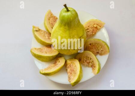 Ganze und Scheiben von Guajava in EINEM kleinen Teller Stockfoto