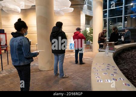 Washington, USA. November 2020. Die Leute stehen vor einem Wahllokal in Arlington, Virginia, USA, am 3. November 2020 zur Abstimmung. Die Wähler in den großen Städten an der Ostküste der Vereinigten Staaten begannen am frühen Dienstag, ihre Stimmabgabe abzusetzen, da sich im ganzen Land weiterhin Umfragen öffnen, um über die Präsidentschaft zu entscheiden. Quelle: Liu Jie/Xinhua/Alamy Live News Stockfoto