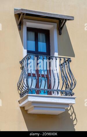 Fenster mit Balkon auf der Fassade mit gusseisernen Verzierungen in Bodrum, Türkei Stockfoto