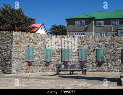 Stanley, Falklandinseln, Großbritannien - 15. Dezember 2008: Gegen graue Steinmauer, grüne Metallplatten mit Namen gefallener Soldaten und Matrosen bei Liberation Stockfoto