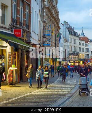 BRÜSSEL, BELGIEN - 06. OKTOBER 2019: Menschenmenge, die in der Dämmerung an der Einkaufsstraße der Altstadt von Brüssel spazieren Stockfoto