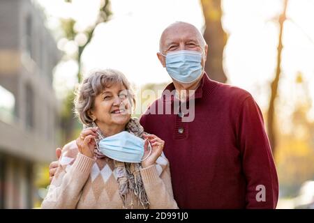 Portrait von älteren Paar trägt Schutzmaske im Freien Stockfoto