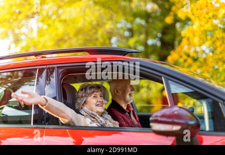 Glückliches älteres Paar, das in ihrem Auto unterwegs ist Stockfoto