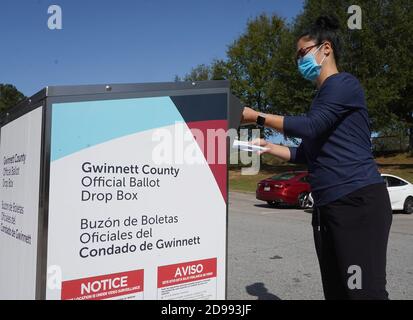 Lawrenceville, Usa. November 2020. Emily Sado legt am Wahltag im Shorty Howell Park in Lawrenceville, Georgia, am Dienstag, den 3. November 2020, ihren Wahlzettel in einer dropbox ab. Foto von Tami Chappell/UPI Credit: UPI/Alamy Live News Stockfoto