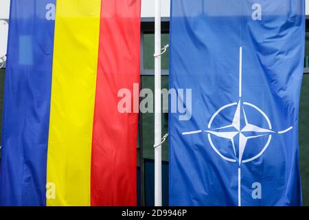 NATO und Rumänien Flaggen nebeneinander vor Eines Gebäudes Stockfoto