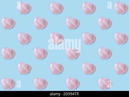 Rose Quarts Kristall Herzen Tapete Hintergrund. Rosa 3D Herzen auf hellblauem Hintergrund. Stockfoto