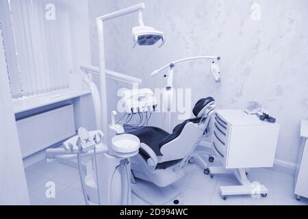 Moderne Zahnarztpraxis. Zahnstuhl und andere Accessoires von Zahnärzten in blau, Sanitäter Licht verwendet Stockfoto