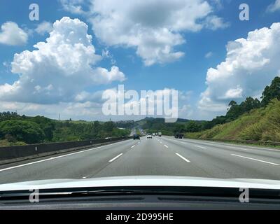 Blick auf ein Auto auf der Landeirantes-Autobahn mit São Paulo und Pico do Jaraguá im Hintergrund. Stockfoto