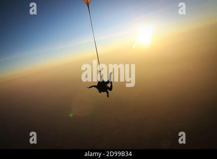 Skydiving Tandem bei dem atemberaubenden Sonnenuntergang Stockfoto