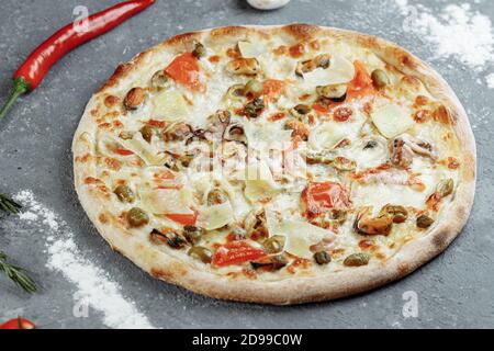 Pizza mit Meeresfrüchten. Pizza mit Mozzarella, Garnelen, Tintenfisch, Muscheln und anderen Meeresfrüchten. Stockfoto