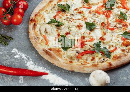 Chicken-Blue Pizza mit Tomaten, Mozzarella und Dor Blue Käse auf grauem Hintergrund Stockfoto