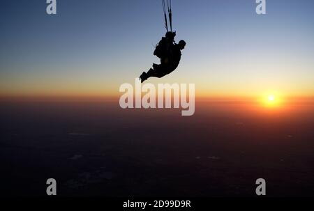 Skydiving Tandem bei dem atemberaubenden Sonnenuntergang Stockfoto