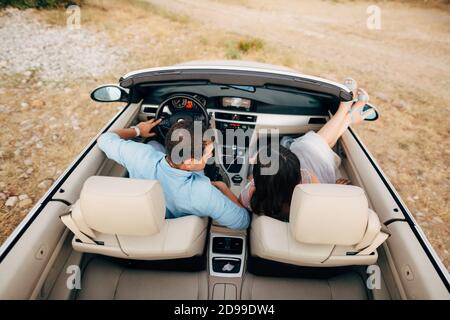 Braut und Bräutigam sitzen im Cabrio Stockfoto