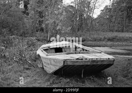 Ein verlassene alte weiße Holzboot ruht in hohem Gras am Ufer des Saugus Flusses bei der Saugus Eisenfabrik. Die Saugus Eisenwerke (ursprünglich Stockfoto