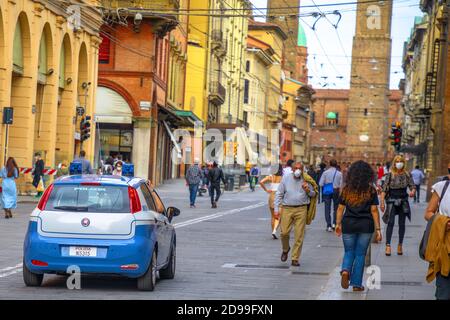 Bologna, Italien - 9. Mai 2020: Polizei patrouilliert Via Ugo Bassi Straße mit zwei Türmen im Hintergrund. Phase 2 Coronavirus nach Quarantäne mit Social Stockfoto