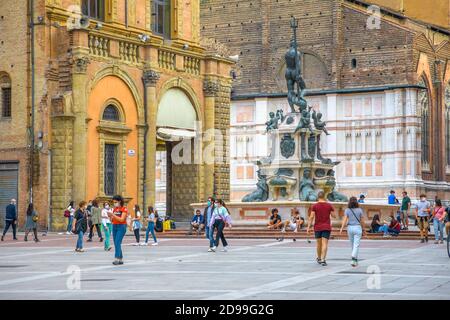 Bologna, Italien - 9. Mai 2020: Phase 2 Covid-19 Tag danach. Paare und Menschen mit OP-Maske auf dem zentralen Platz der Piazza Maggiore mit Neptun-Statue Stockfoto