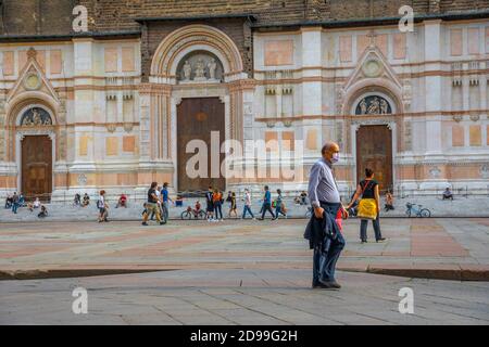 Bologna, Italien - 9. Mai 2020: Mann mit OP-Maske auf dem zentralen Platz der Piazza Maggiore mit der Basilika San Petronio. Phase 2, der Tag nach Covid-19 Stockfoto