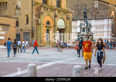 Bologna, Italien - 9. Mai 2020: Phase 2 Coronavirus. Paare und Familien mit OP-Maske auf dem zentralen Platz der Piazza Maggiore mit Neptun-Statue Stockfoto