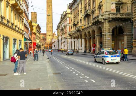 Bologna, Italien - 9. Mai 2020: Polizei patrouilliert Via Rizzoli Straße mit zwei Türmen im Hintergrund. Phase 2 Coronavirus nach Quarantäne mit Social Stockfoto