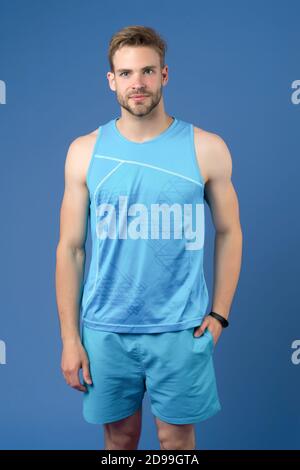 Sportkleidung. Outfit für bessere Ergebnisse. Sportlertraining mit Schrittzähler. Sportgerät Konzept. Mann Athlet Sportausrüstung violetter Hintergrund. Sportler mit Borsten tragen Fitness-Tracker. Stockfoto