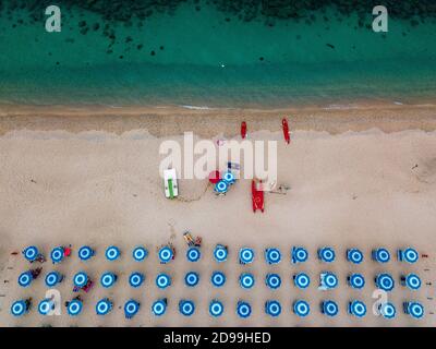 Luftaufnahme des Strandes und der Sonnenschirme. Tropea, Kalabrien, Italien. Parghelia. Überblick über den Meeresboden von oben gesehen, transparentes Wasser. Schwimmer, Badegäste Stockfoto