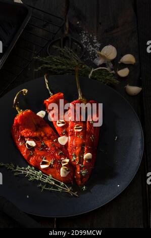 Geröstete rote Paprikaschoten mit Knoblauch und Thymiangewürzen Schwarz Stockfoto