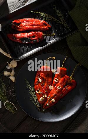 Geröstete rote Paprikaschoten mit Knoblauch und Thymiangewürzen Schwarz Stockfoto