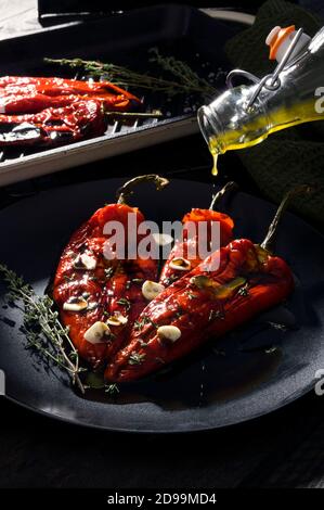 Geröstete rote Paprikaschoten mit Knoblauch und Thymiangewürzen Schwarz Stockfoto