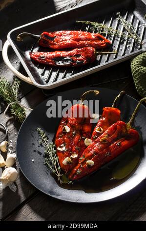 Geröstete rote Paprikaschoten mit Knoblauch und Thymiangewürzen Schwarz Stockfoto