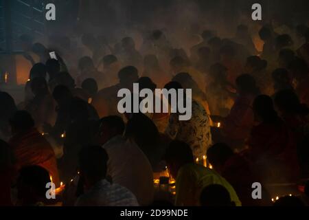 Narayanganj, Bangladesch. November 2020. Hunderte von hinduistischen Anhängern versammeln sich vor Shri Shri Loknath Brahmachari Ashram Tempel für das Rakher Upobash, ein religiöses Fest namens Kartik Brati, in Barodi, ohne soziale Distanz inmitten der COVID-19 Krise zu halten. Sitzen vor Kerzenlicht, fasten und beten sie ernsthaft zu den Göttern für ihre Gunst während des Rituals. (Foto von Joy Saha/Pacific Press) Quelle: Pacific Press Media Production Corp./Alamy Live News Stockfoto