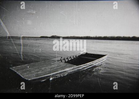 Feine 70er Jahre Vintage Schwarz-Weiß-Fotografie von einem Fischerboot, das am Ufer wartet. Stockfoto