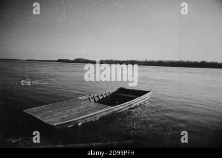 Feine 70er Jahre Vintage Schwarz-Weiß-Fotografie von einem Fischerboot, das am Ufer wartet. Stockfoto