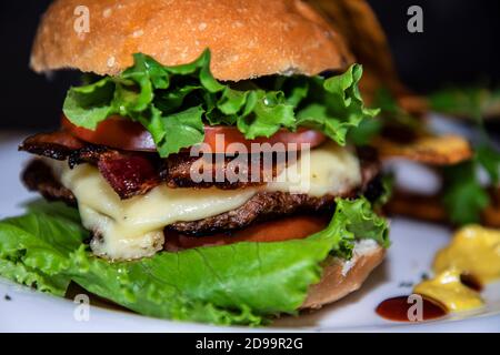 Nahaufnahme eines großen Burgers mit etwas Gemüse Stockfoto