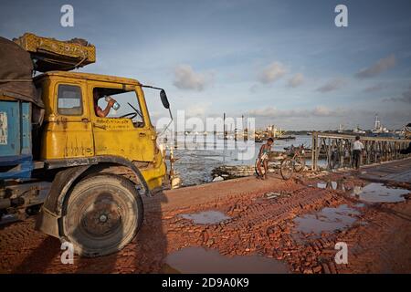 Chittagong, Bangladesh, Juli 2009 - EIN Lastwagen wartet auf eine Brücke auf einer verfallenen Straße, die mit Wasser und Schlamm gefüllt ist. Stockfoto