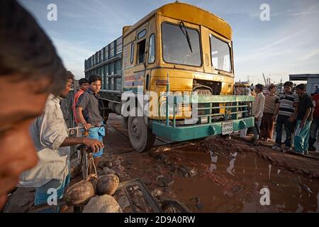 Chittagong, Bangladesh, Juli 2009 - EIN Lastwagen wartet auf eine Brücke auf einer verfallenen Straße, die mit Wasser und Schlamm gefüllt ist. Stockfoto