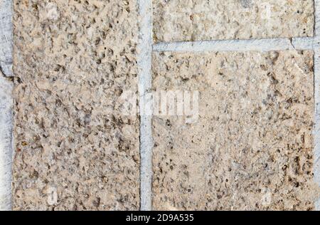 Die Textur des hellen Steins, der die Straße zum Palast des Herodes in Cäsarea gepflastert hat, Hintergrund. Stockfoto