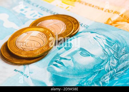 In dieser Fototafel werden die echten Münzen auf die brasilianische Banknote in goldenem Ton gelegt. Stockfoto