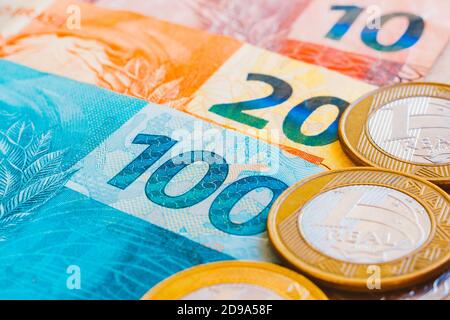 In dieser Fototafel werden die echten Münzen auf die brasilianische Banknote in goldenem Ton gelegt. Stockfoto