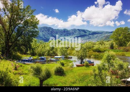 Virpazar, Montenegro - 05-30-2019: Verankerte Ausflugsboote in der Nähe der Brücke in Virpazar Stadt, Beginn der touristischen Saison Stockfoto