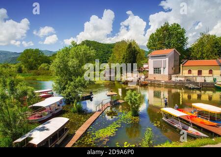 Virpazar, Montenegro - 05-30-2019: Verankerte Ausflugsboote in der Nähe der Brücke in Virpazar Stadt, Beginn der touristischen Saison Stockfoto