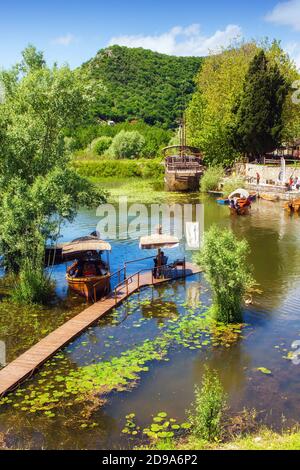 Virpazar, Montenegro - 05-30-2019: Verankerte Ausflugsboote in der Nähe der Brücke in Virpazar Stadt, Beginn der touristischen Saison Stockfoto