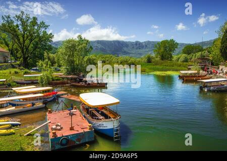 Virpazar, Montenegro - 05-30-2019: Verankerte Ausflugsboote in der Nähe der Brücke in Virpazar Stadt, Beginn der touristischen Saison Stockfoto