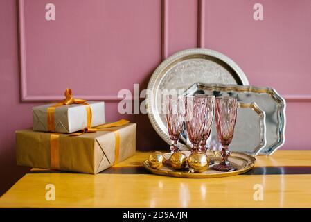 Rosa Gläser, Geschenkboxen, Weihnachtsbaumkranz, Metalltabletts in der rosa Küche. Weihnachtsdekor im Haus Stockfoto