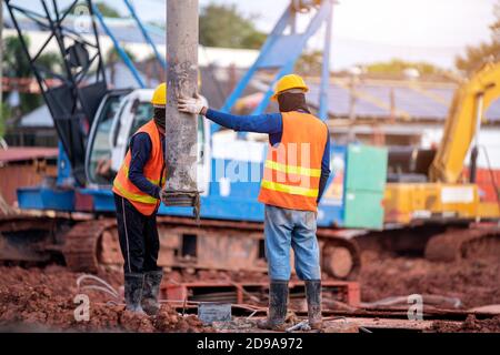 Bauarbeiter Installation von Rohren für Betongießen während der kommerziellen Betonböden des Gebäudes auf der Baustelle Stockfoto