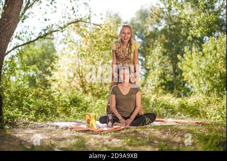 Massagetherin wendet ihre Massagefähigkeiten auf ihren Klienten in der Natur an. Stockfoto