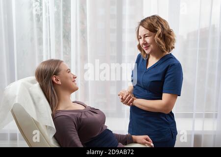 Der Arzt spricht mit einer jungen Patientin in ihrem Büro Stockfoto