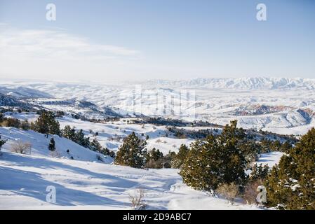 Das majestätische Tien Shan Gebirge im Winter in Usbekistan. Wunderbare Winterlandschaft. Atemberaubende Hochland an einem sonnigen Tag. Herrliche Aussicht auf schneebedeckte m Stockfoto