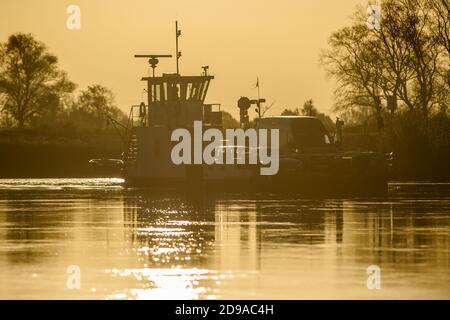 04. November 2020, Sachsen-Anhalt, Rogätz: Die Elbfähre Rogätz bringt die ersten Pendler bei Sonnenaufgang über den Fluss. Ein sonniger Tag steht für Mitteldeutschland bevor. Es wird kälter sein als in den letzten Tagen. Foto: Klaus-Dietmar Gabbert/dpa-Zentralbild/ZB Stockfoto