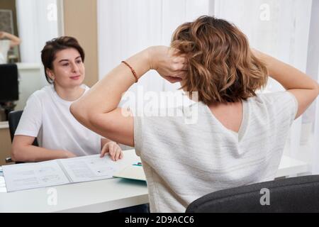 Arzt oder Massage-Spezialist Beratung junge Frau über Kopfschmerzen Stockfoto